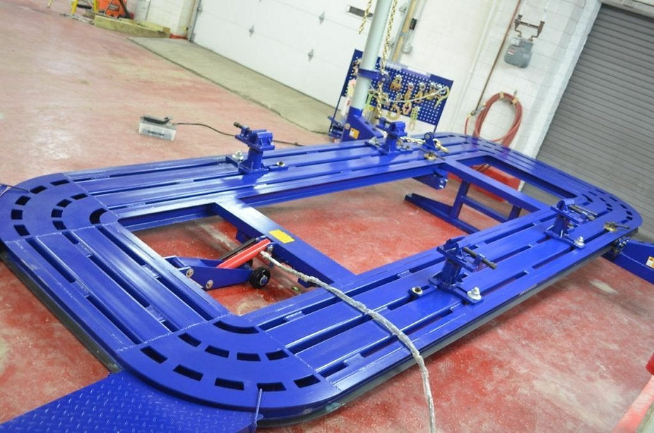 18-foot frame straightener machine with hydraulic tilt bed and 10-ton pulling towers.